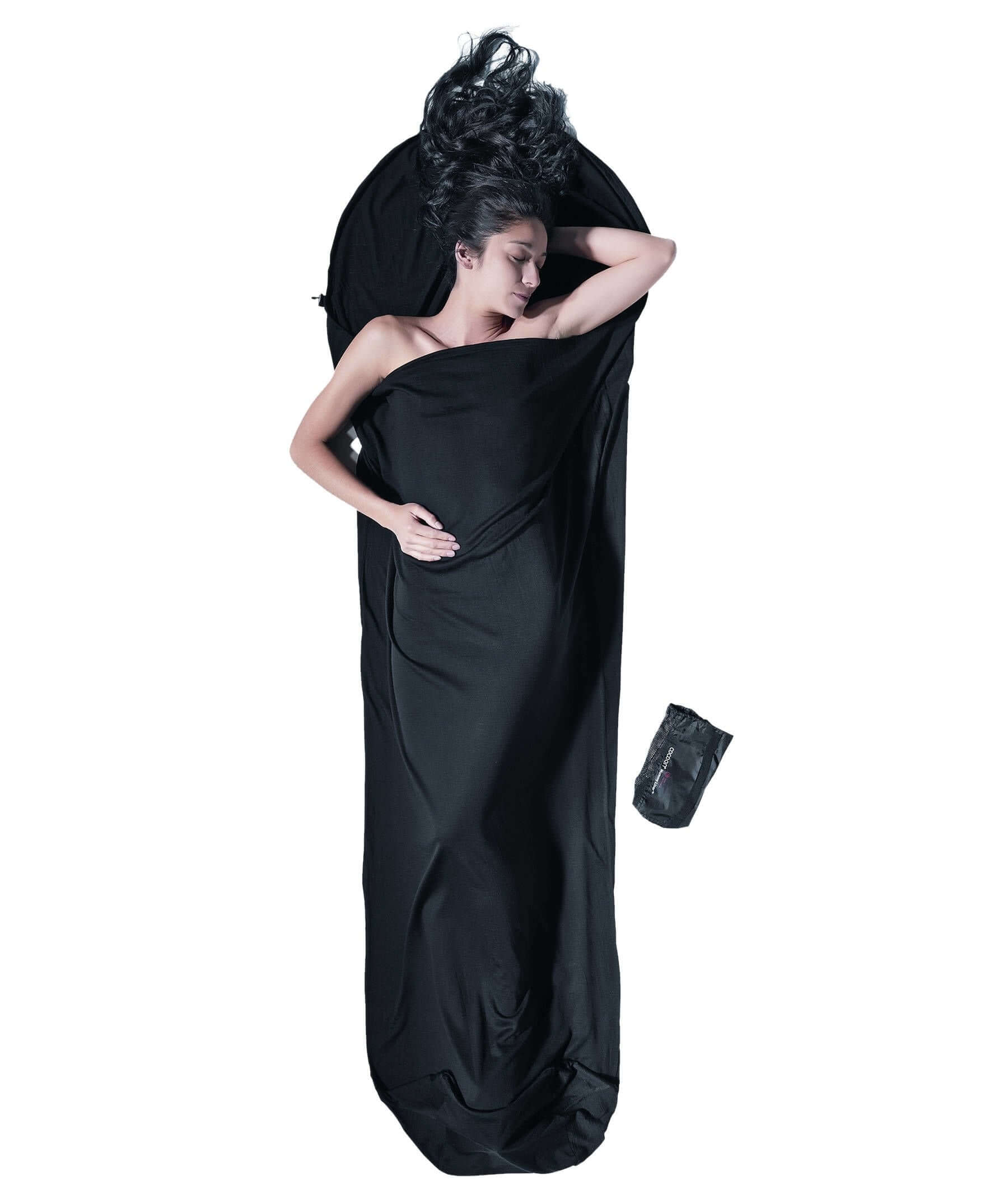 Hier sieht man eine Dame die im Cocoon MummyLiner – Hüttenschlafsack aus Merinowolle schläft