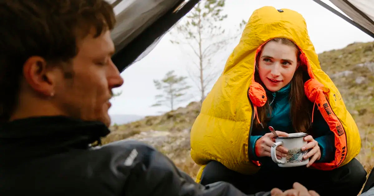 Mann und Frau beim Campen mit ihren Outdoor Equipment, es wird über das nächste Ziel diskutiert.