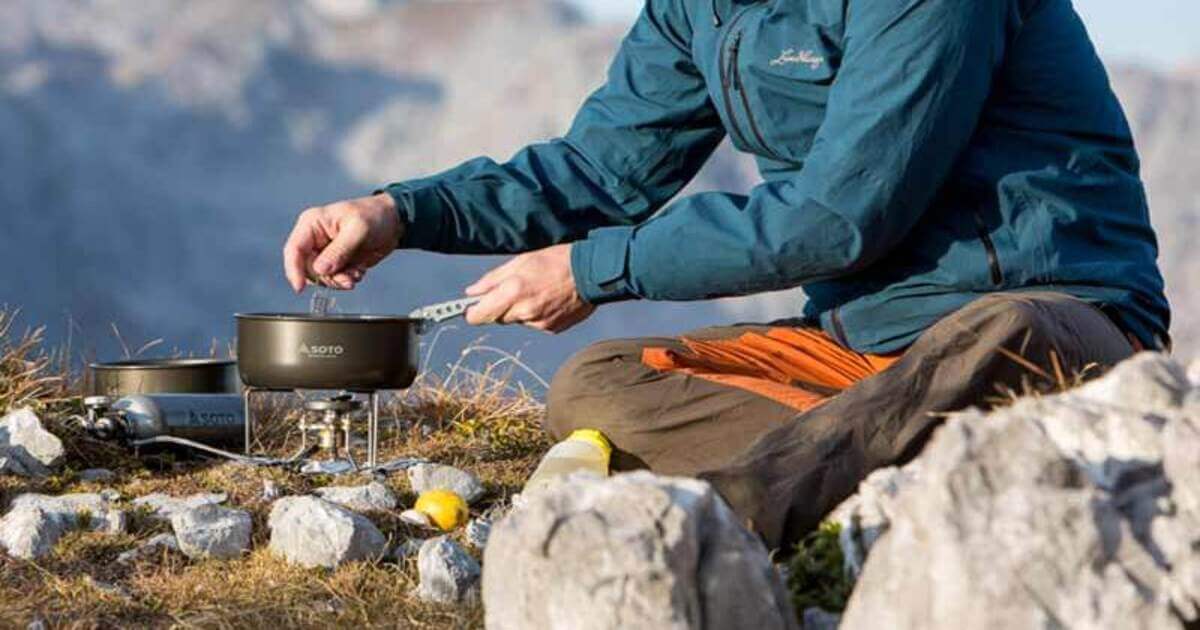 Mann in den Bergen beim Kochen mit seinem Soto Outdoor Equipment
